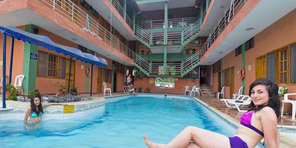 Patio interior de un hotel urbano de San Gil con piscina rectangular rodeada de habitaciones en varios pisos