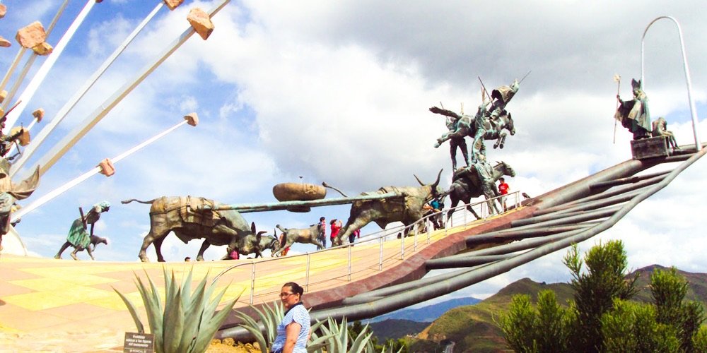Monumento a la Independencia en el Parque Nacional del Chicamocha, con esculturas de bueyes, jinetes y campesinos contra el cielo