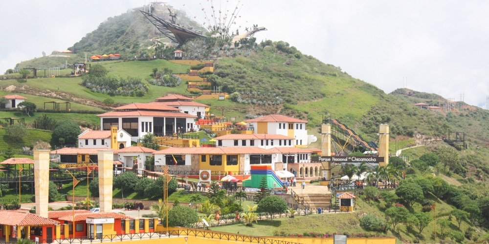 Vista aérea del Parque Nacional del Chicamocha con el monumento en la cima del cerro, la zona de restaurantes y el teleférico bajando hacia el cañón