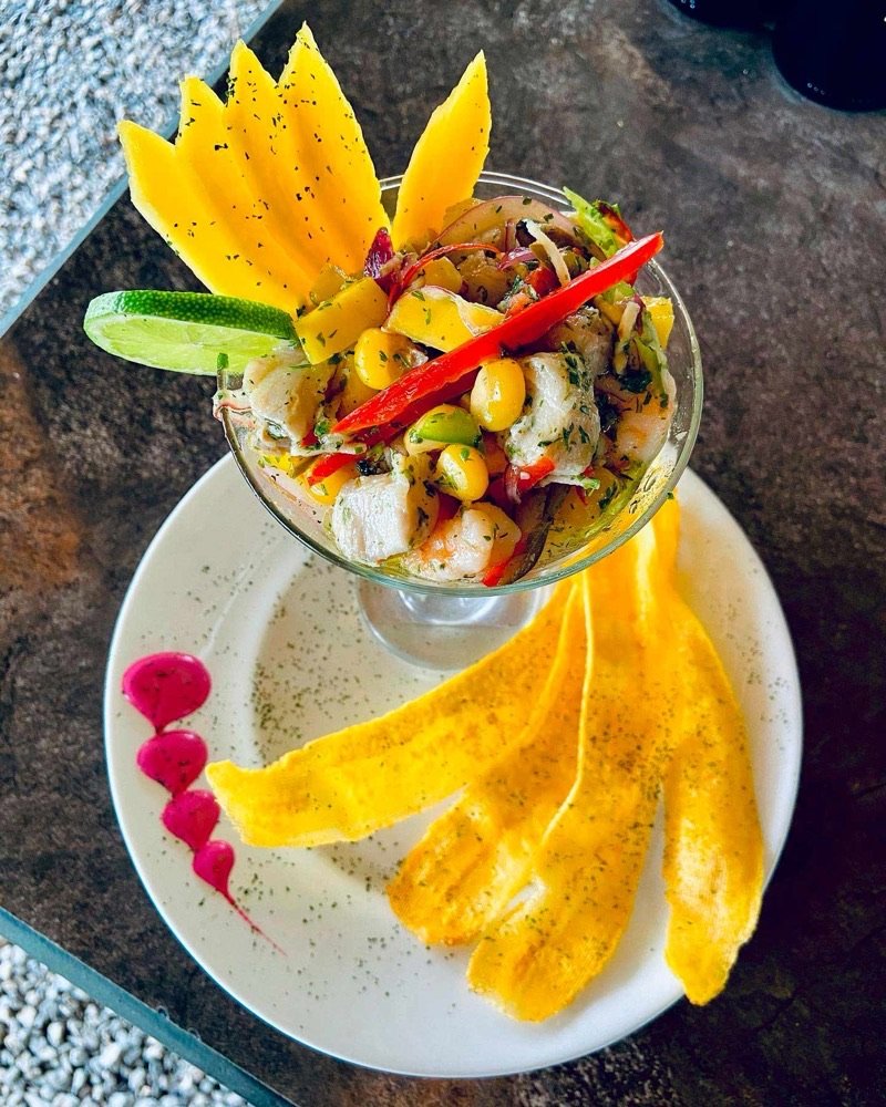 Copa de ceviche con camarones, mango y ají decorada con tajadas de plátano maduro horneadas, servida en un restaurante de San Gil