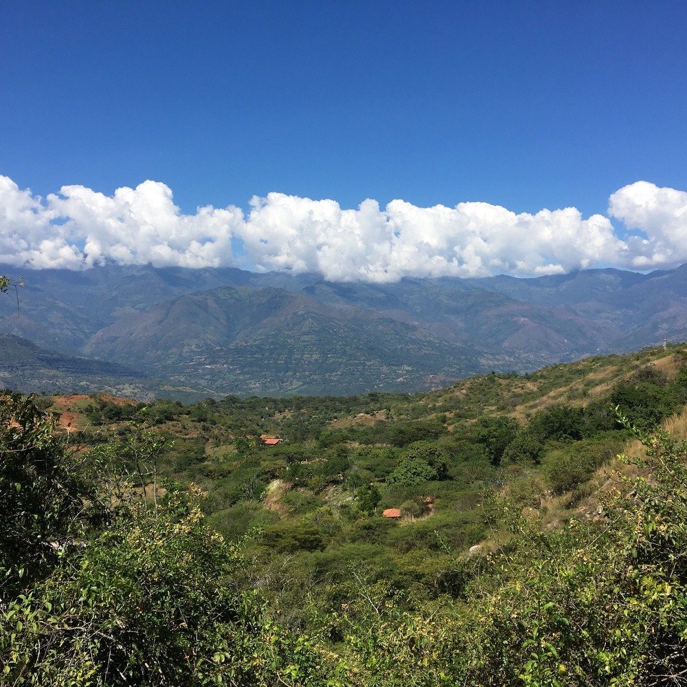 Vista panorámica del valle santandereano desde lo alto del Camino Real, con montañas escalonadas y nubes bajas